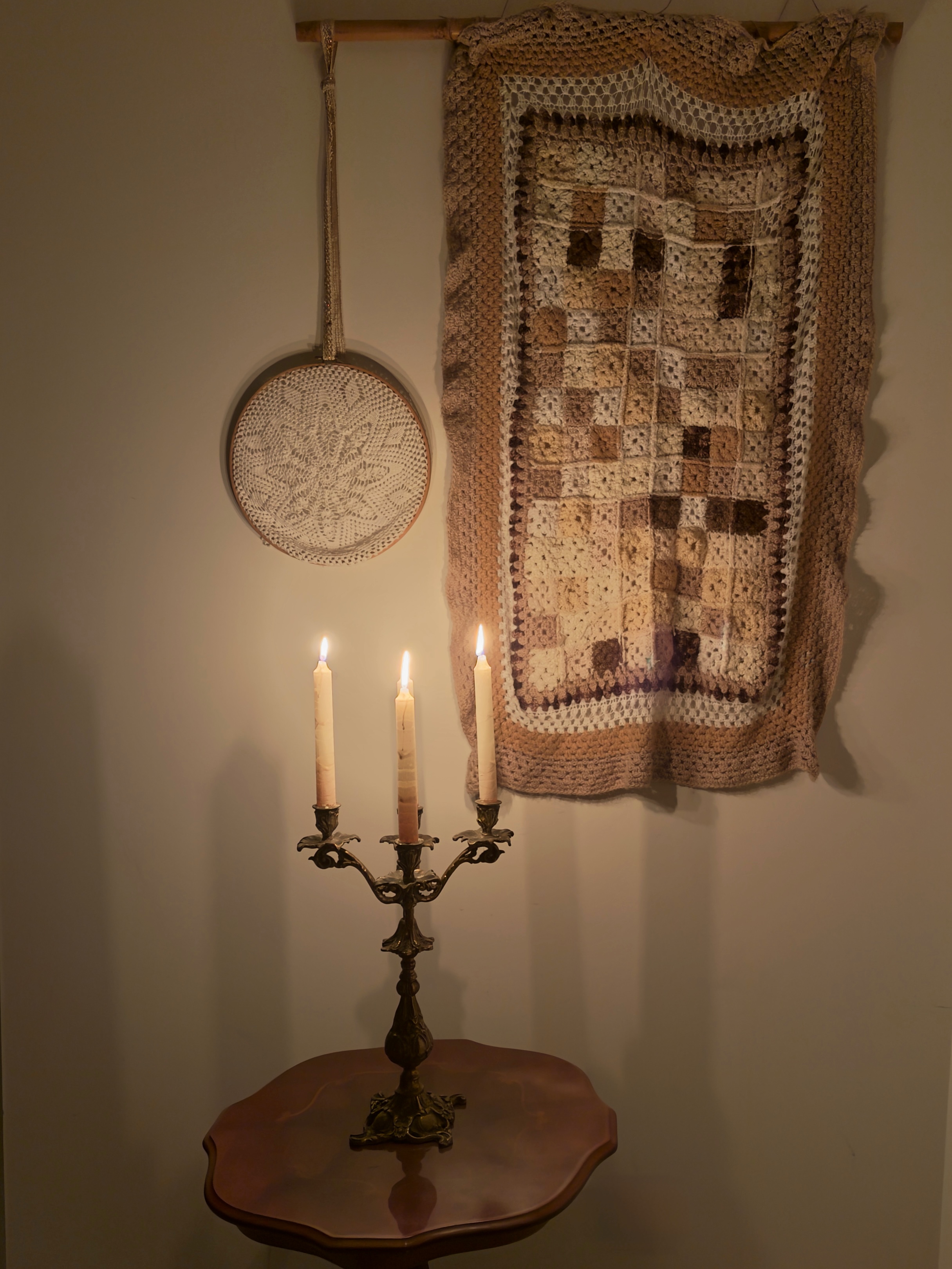 Candelabra lighting up handmade crochet wall hangings.