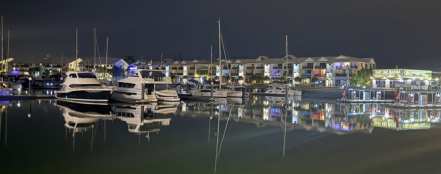 Raby Bay Harbour. Boats in a harbour with reflections in the water below them.