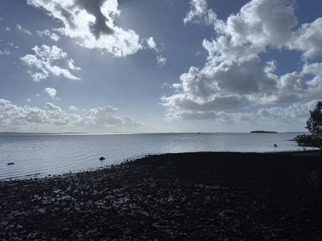 A rocky beach with clouds in the sky.